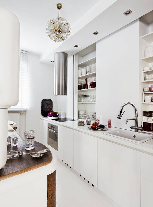 Fitted kitchen counter with sliding elements in front of shelving